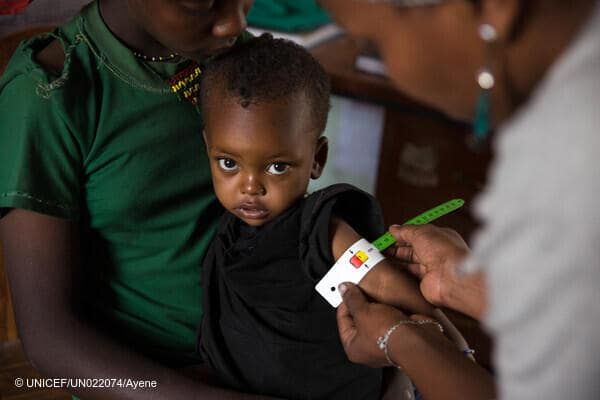 28-month-old Nebila has her mid-upper-arm circumference measured by a Health Extension Worker as she sits in the lap of her 12-year-old sister Zekiya. Nebila was diagnosed with severe acute malnutrition a week ago, and has been receiving treatment including ready-to-use-therapeutic food (RUTF).