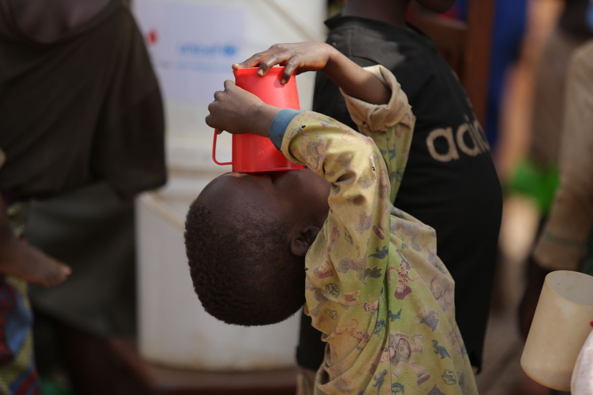 A child drinking water at the IDP site in Mubimbi