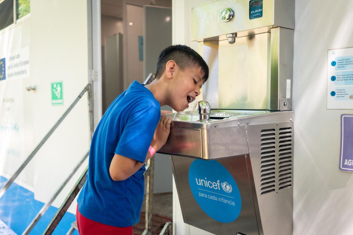 Child drinking water in a water purification plant 