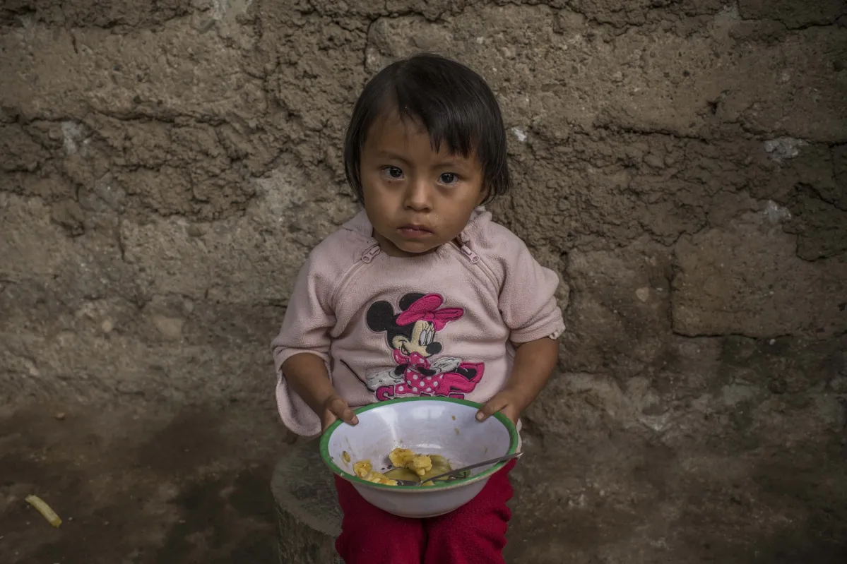 Mariela de 1 años come una banana en Guatemala. 