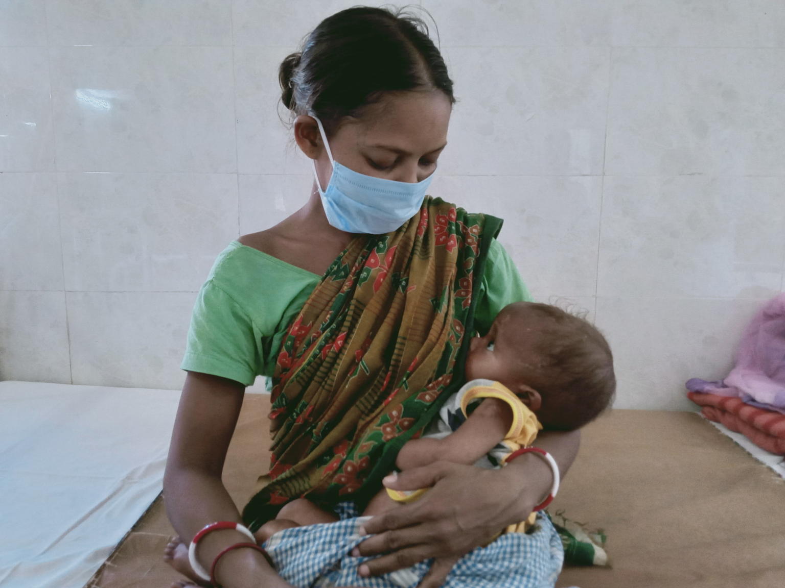 Mother in mask breastfeeding