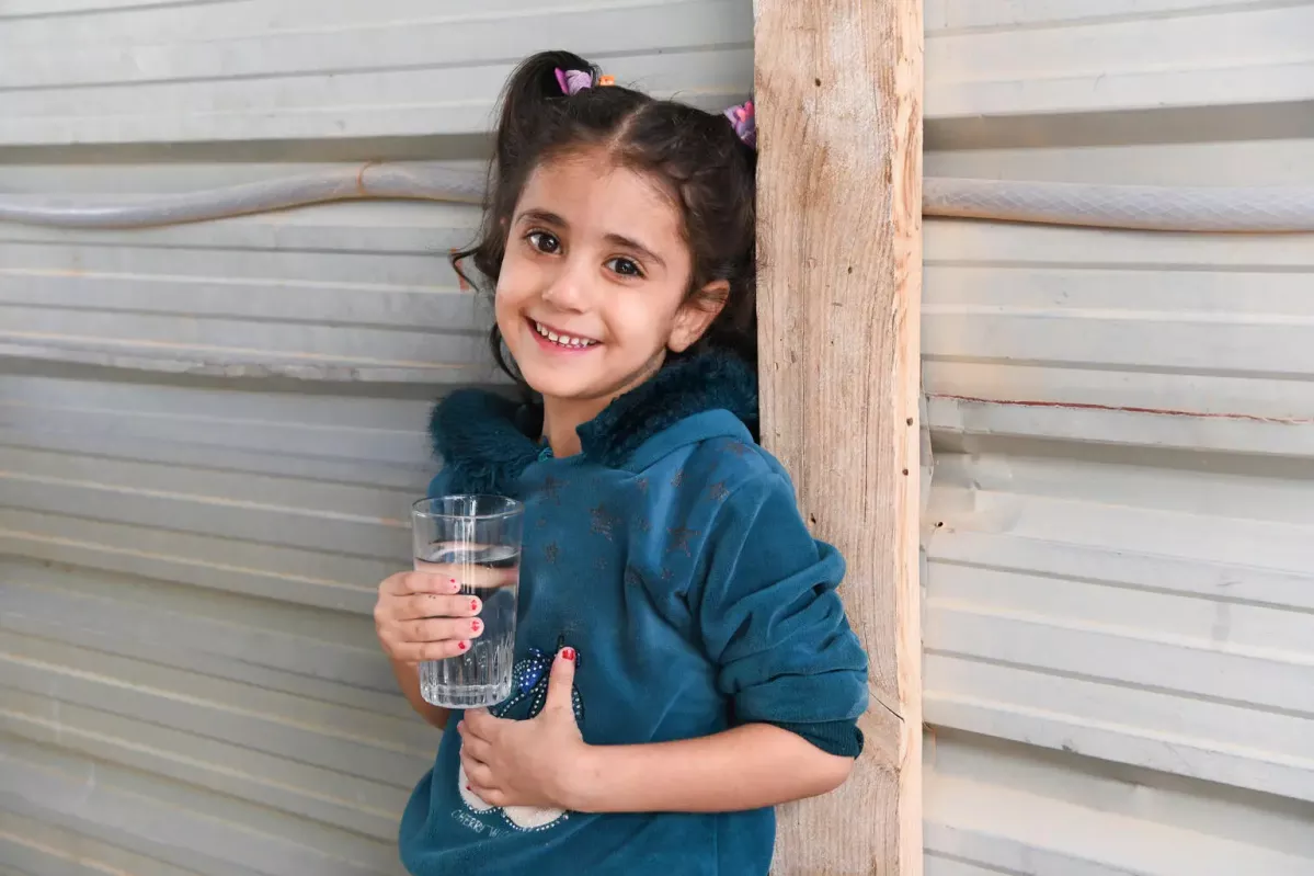 Shahd, 5, drinks water at home in Za'atari refugee camp.