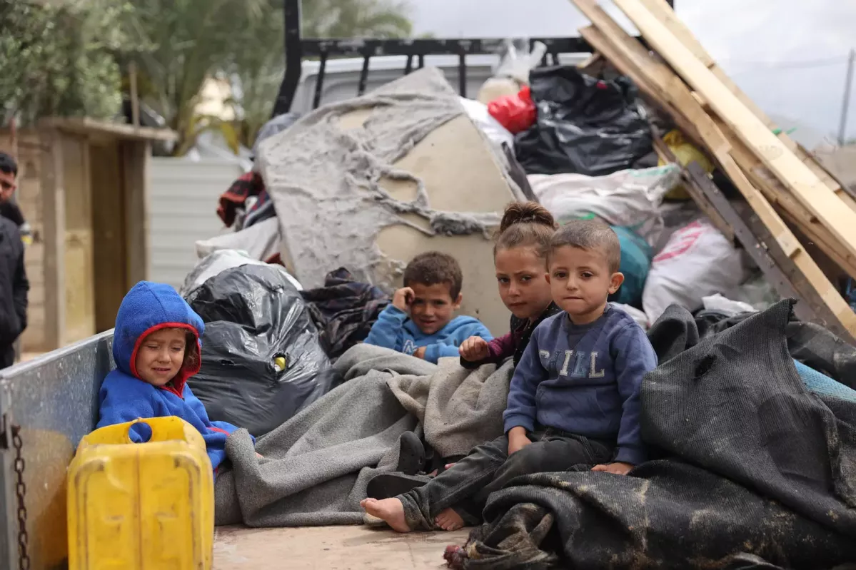 Children sitting in the back of a truck during their displacement from areas witnessing an escalation