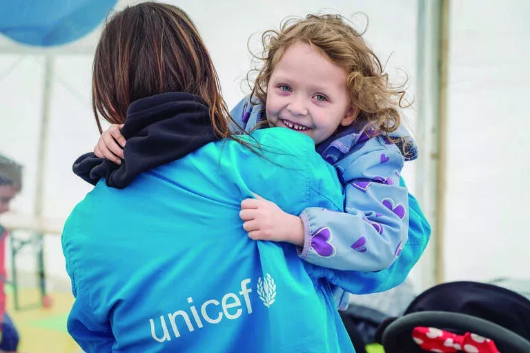 Girl plays with a UNICEF staff member