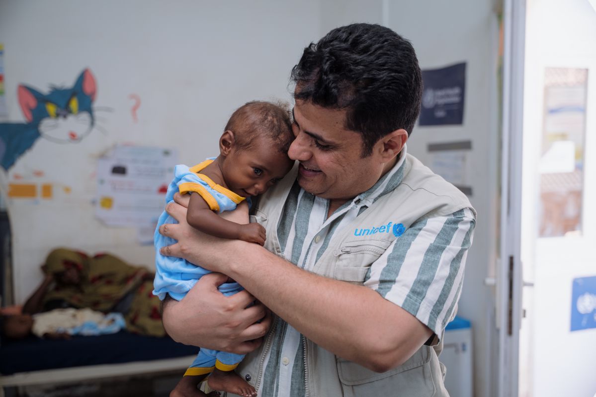 UNICEF staff holding a child in Sudan UNICEF facility