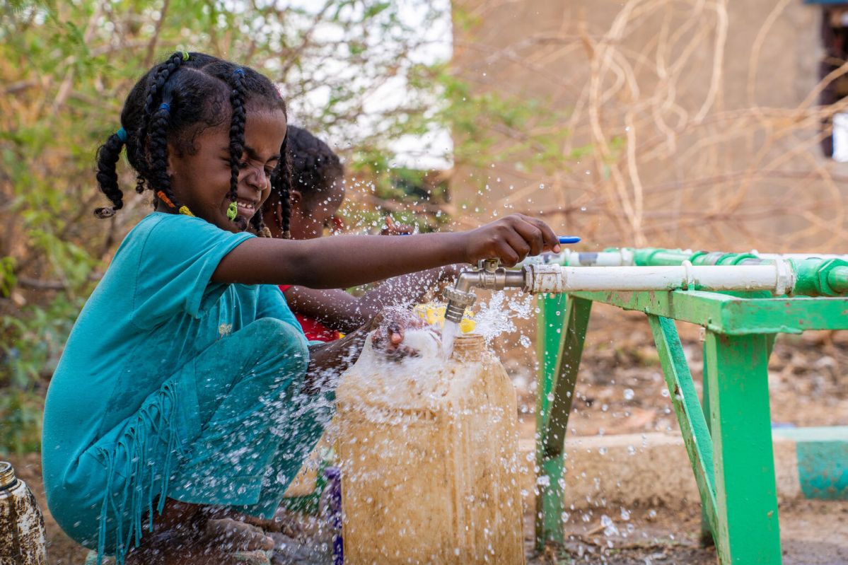 Child, Amna playing with water in Sudan