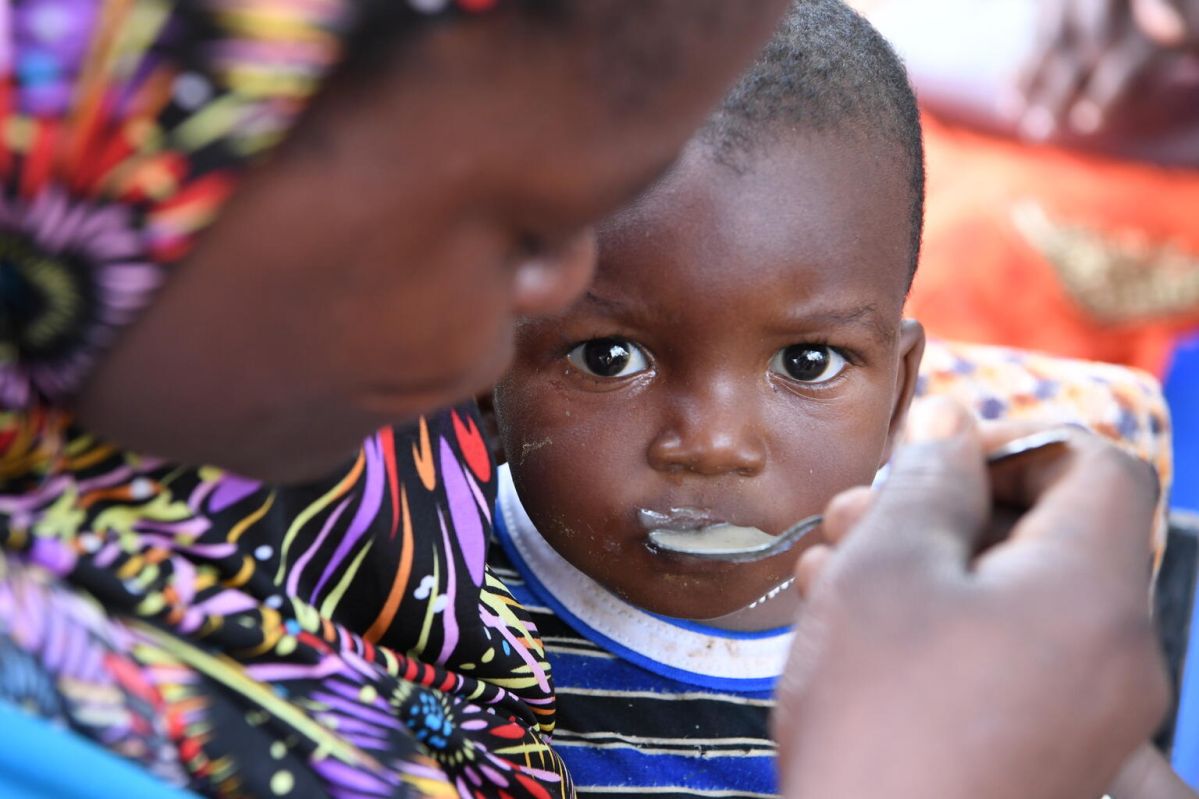A close-up of a mother feeding her child with a spoon