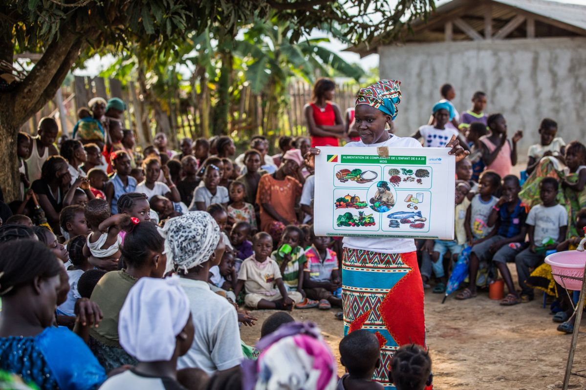A woman explaining nutritious food for children to other women and caregivers