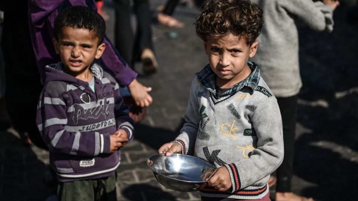 Ahmad, 5-years-old, waits his turn in the crowd to get a meal from a charitable hospice that distributes free food in the city of Rafah, southern Gaza Strip.